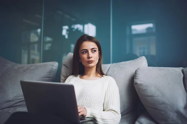 Pensive Female Freelancer Casual Clothes Looking Away While Sitting Sofa — Stock Photo, Image