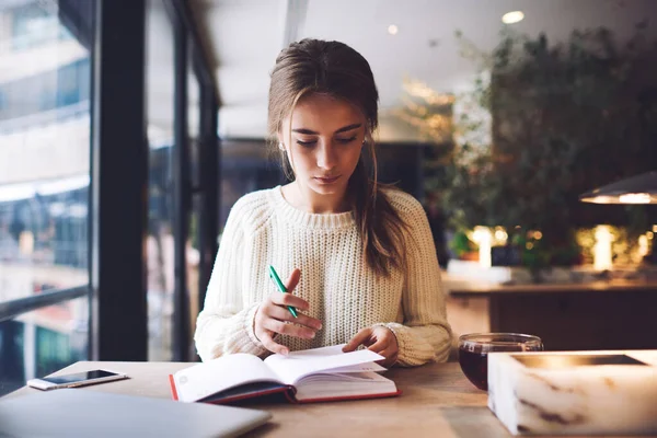 Mujer Joven Pensativa Suéter Ligero Tomando Notas Cuaderno Mientras Está —  Fotos de Stock