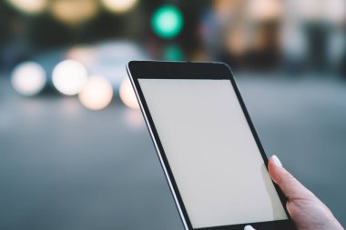 Beyaz tırnak cilası ile manikürlü yüzü olmayan, modern elektronik kablosuz tableti olan, boş ekranlı ve düğmeli bir kadın.