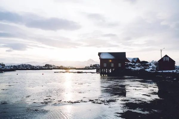 Typiska Bostadshus Stranden Porlande Hav Lågvatten Omgivet Snöiga Kullar Mot — Stockfoto