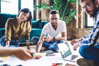 Girişim projesinde işbirliği yapan bir grup genç hippi birlikte çalışma alanında gündüz vakitlerini geçiriyorlar, çeşitli öğrenciler yerde oturuyor ve tasarımı geliştirirken eğitim bilgilerini tartışıyorlar.