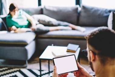 Kesilmiş erkek blogcu boş ekran ile dokunmatik ped uygulaması ile online rezervasyon ve bankacılık yapan bin yıllık adam, metin alanınızın fotokopi alanı ile birlikte web reklamında geziniyor.