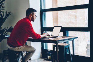 Yetenekli erkek serbest yazar, internet reklamcılığı için fotokopi alanı ile modern laptop teknolojisi üzerinden ortaklarla iletişim kurar, adam boş ekran ile Netbook 'ta içerik yayınını araştırır