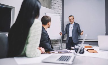İşletme projesi için bilgi açıklayan profesyonel ekonomist, başarılı iş adamları şirket sunumunda danışmanlığı tartışırken birlikte iş birliği yapıyorlar