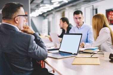 Profesyonel yöneticilerden oluşan bir grup, dizüstü bilgisayarda fotokopi alanı olan internet yayınları için finansal reklam metni hakkında iletişim kuruyor, erkek ve kadın ortaklar boş bir ağ kitabı kullanıyor ve bunu taklit ediyorlar.