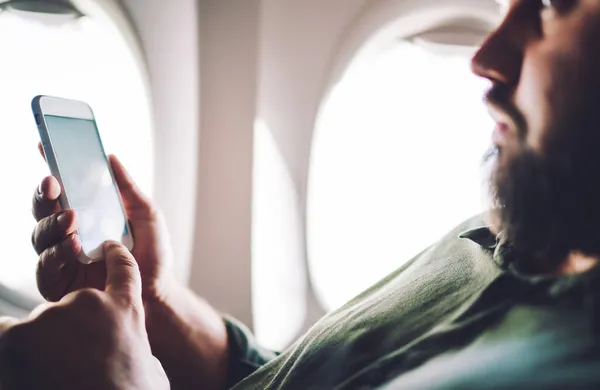Вид Збоку Людину Повсякденному Одязі Переглядає Смартфон Сидячи Літаку Літаючи — стокове фото