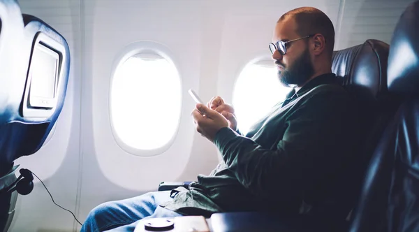 비행기에 안경을 평상복을 핸드폰을 사용하는 — 스톡 사진