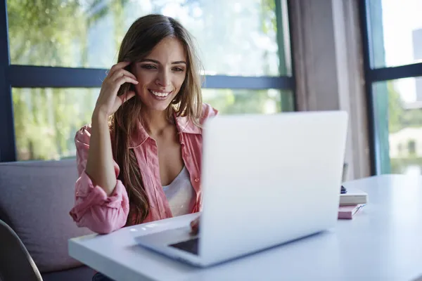 God Kvinnelig Frilanser Leser Rare Budskap Smiler Med Laptop Computer – stockfoto