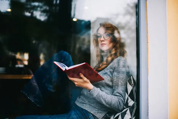 Través Ventana Mujer Reflexiva Con Gafas Cabello Ondulado Mirando Hacia —  Fotos de Stock