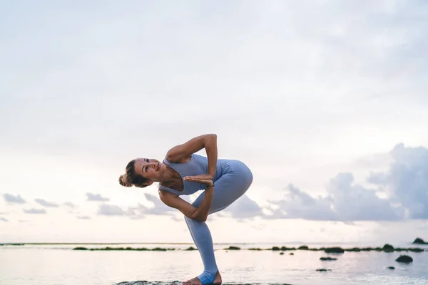 柔韧的女性瑜伽选手在海滨练习Hatha伸展身体肌肉以保持身材完美 白种人女孩在海滨练习普拉提时享受大自然的启发 — 图库照片