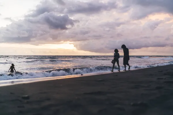 발가벗고 맨발로 다니는 알아볼 수없는 실루엣으로 사람들 해변의 놀라운 광경을 — 스톡 사진