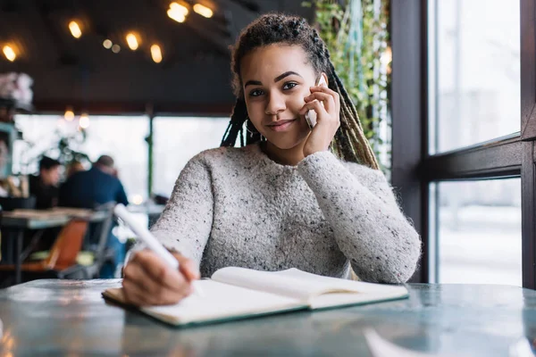 在咖啡店学习教育的过程中 漂亮的非洲裔美国学生喜欢用智能手机交谈 聪明的女性博客写手的肖像 并计划用手机上网打电话 — 图库照片