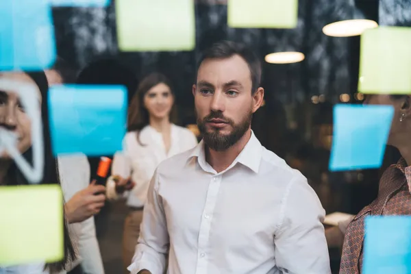 Thoughtful Bearded Man White Shirt Looking Glass Wall While Working — Stock Photo, Image