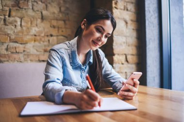 Günlük giysiler içindeki kız öğrencilerin masada oturup, cep telefonlarını karıştırırken ve ödev yaparken not almalarına sevindim.