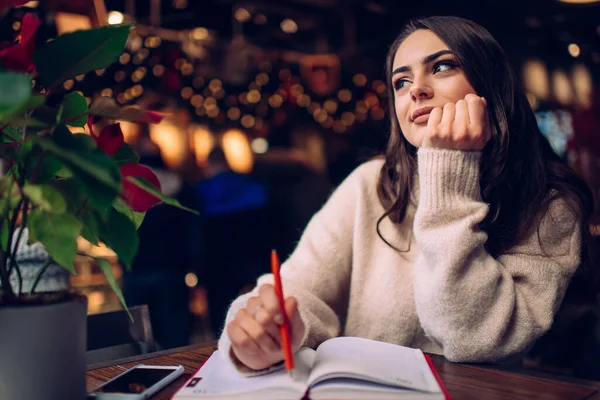 Pensive Young Lady Sweater Sitting Hand Chin Pen Notebook Cozy — Stock Photo, Image