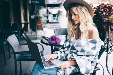 Millennial moda blogcusu, boş zamanlarında sosyal medyada dizüstü bilgisayar ağı kurmak için dizüstü bilgisayar kullanıyor, genç serbest çalışan, modern ağ kitabında 4G kablosuz ağa bağlanan bilgileri tarıyor