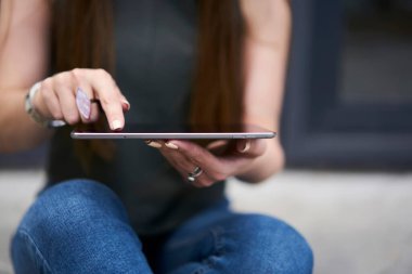 Sosyal medyada sohbet etmek ve mesajlaşmak için modern dokunmatik ped teknolojisini kullanan tanınmayan kadın blogcu, dijital tablet üzerinde ağ web sitelerine göz atarken posta yazmak için kesilmiş kadın