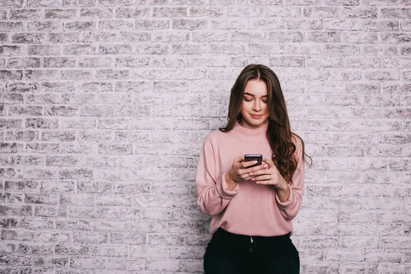 Улыбающаяся Женщина Повседневной Одежде Смотрит Экран Мобильного Телефона Проверяя Социальные — стоковое фото