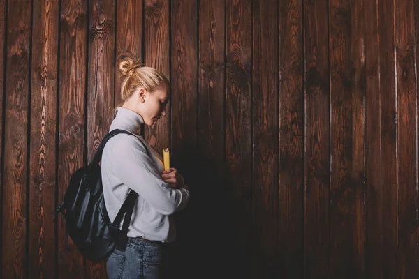 Sırt Çantalı Ciddi Bir Bayan Öğrencinin Ahşap Duvarın Yanında Durup — Stok fotoğraf