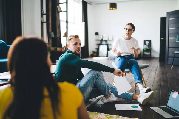 Gayri resmi kıyafet paylaşım projesi önerileri içinde genç çok ırklı meslektaşlardan oluşan bir grup. İç işlerinde çalışırken grafikleri analiz ediyorlar.