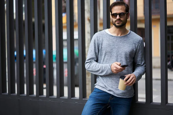 Ernstige Jonge Man Casual Kleding Zonnebril Browsen Mobiele Telefoon Genieten — Stockfoto