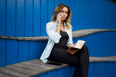 Cep telefonu görüşmeleri sırasında not defteri planlama organizasyonu olan genç bir öğrenci. Şehirde ders kitabı okuyan, gezen, zeki, beyaz bir kadın. Eğitim hakkında bilgi almak için çağrıda bulunuyor.