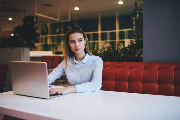 Imprenditrice Concentrata Camicia Leggera Seduta Tavola Portatile Navigante Mentre Lavora — Foto Stock