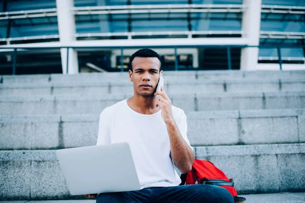 Konsentrert Afroamerikansk Frilanser Vanlige Klær Sittende Med Laptop Knærne Snakke – stockfoto