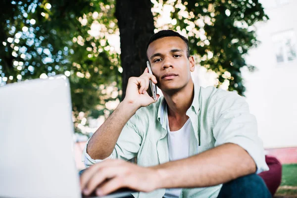 Młody Czarny Mężczyzna Freelancer Siedzi Przenośny Netbook Letni Ogród Podczas — Zdjęcie stockowe
