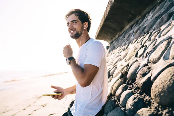 Positive Bearded Male Casual Wear Standing Sandy Beach Sea Listening — Stock Photo, Image