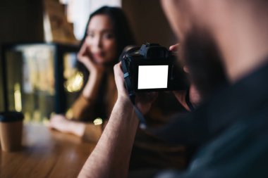 Yetenekli fotoğrafçıların arka görüntüsü fotoğrafçıyı modern SR kamera kullanarak reklamcılık ve fotoğrafçılık için ekran oluşturur. Boş zamanlardaki resimlere tıklamak için seçici bir şekilde boş teknolojiye odaklanır.