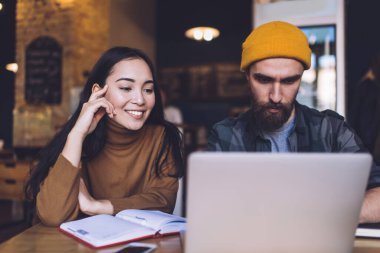 İnternet üzerinden internet semineri izleyen mutlu Kafkas öğrencileri üniversite proje araştırmaları yararlı bilgiler üzerinde işbirliği yaparken, internet üzerinde çalışan zengin hipster erkekler web sitesine göz atıyorlar.