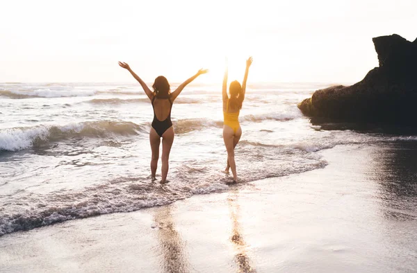 Powrót Widok Anonimowych Dziewczyn Strojach Kąpielowych Spacerujących Piankowych Falach Oceanu — Zdjęcie stockowe