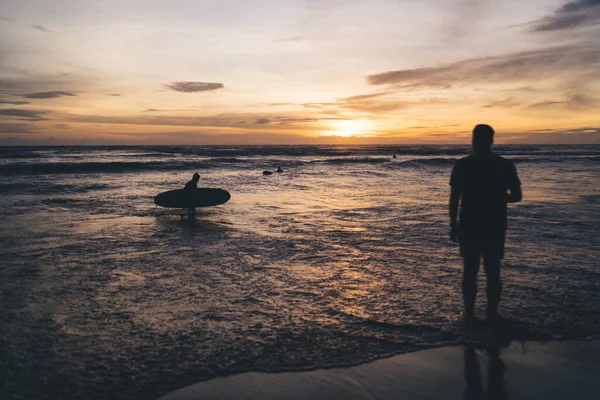 Silhouettes Anonymous Unrecognizable Men Water Tranquil Rippling Ocean Washing Sandy — Stock Photo, Image