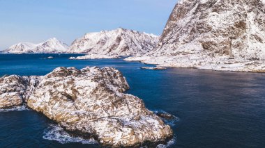 Kışın karla kaplı görkemli fiyort dağlarının nefes kesici kuş bakışı görüntüsü. Hava manzaralı kaya zirveleri, resim gibi güzel doğa manzarası. Lofoten Adası İskandinav Denizi ile çevrilidir