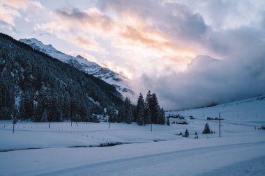 Doğanın manzaralı doğal manzarası kuzey topraklarında nefes kesici günbatımında, kış dağları İskandinavya 'da buz ve karla kaplı
