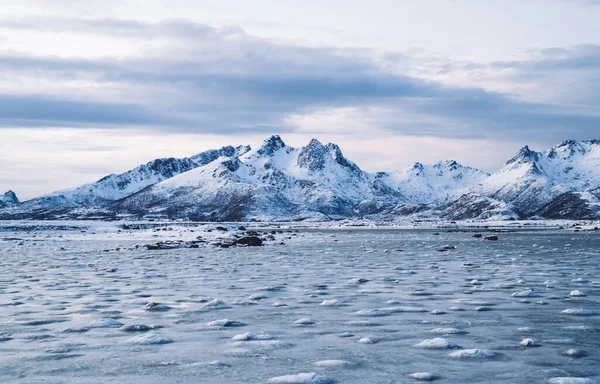 얼어붙은 노르웨이 협만의 눈덮인 산들이 차가운 겨울에는 하늘을 뒤덮고 아름다운 — 스톡 사진