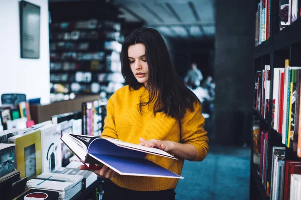 Koncentrerad Ung Dam Avslappnade Kläder Läser Intressant Bok Inbunden Medan — Stockfoto