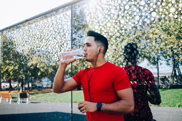 Sporty Man Standing Next Decorated Glass Wall Drinking Water Bottle — Stock Photo, Image
