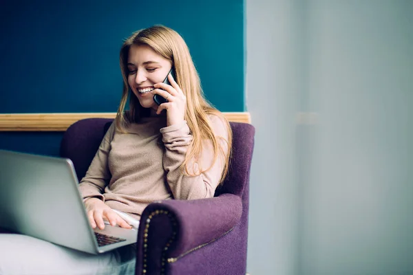 Glad Ung Kvinne Tilfeldig Antrekk Sittende Moderne Lenestol Med Laptop – stockfoto