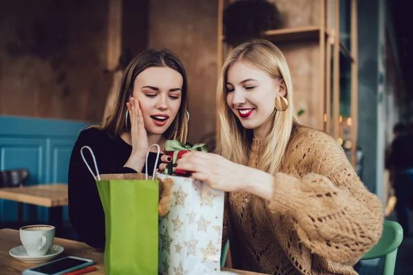 Aufgeregte Freundinnen Lässiger Kleidung Lächeln Und Tauschen Geschenke Aus Während — Stockfoto