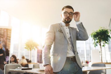 Çağdaş iş merkezindeki modern ofiste şık giyimli ciddi, iyi giyimli erkek girişimcinin alçak açısı.