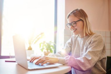 Gözlüklü komik yeniyetme kız internetten kablosuz rezervasyon yaparken komik web sayfasına göz atıyor, neşeli Kafkasyalı blogcu içerik planlarını kontrol ederken netbook uygulaması üzerinden sosyal medyaya bağlanıyor.