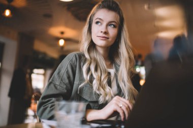 Yazlık ceketli, düşünceli bir bayan, kafeteryada oturmuş, netbook 'la uzaktan yakından ilgilenirken gözlerini kaçırıyor.