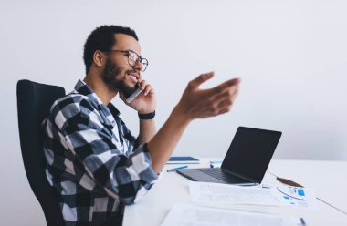 Klasik göz giysisi içinde profesyonel işveren, netbook teknolojisi üzerine metin reklamları hakkında konuştuğu için meslektaşına sesleniyor, milenyum yöneticisi ofisteki telefon uygulamasını cep telefonu uygulaması ile kullanıyor.