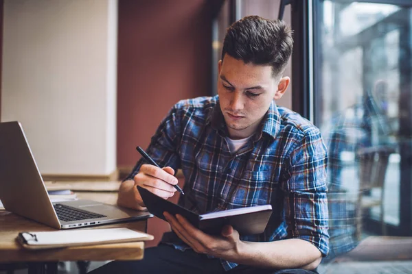 Skoncentrowany Mężczyzna Freelancer Noszenie Ubrań Casual Siedzi Kawiarni Pisanie Informacji — Zdjęcie stockowe