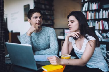 Beyaz tişörtlü, kahve içen ve not defterinden bilgi okuyan genç bir bayan. Sınava hazırlanırken yanında laptoplu ve kitaplı bir erkek arkadaşı vardı.