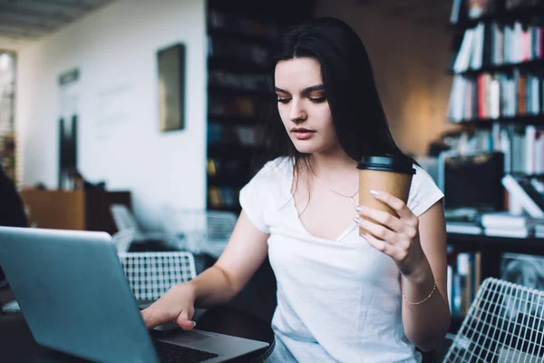 Fokuserad Ung Kvinnlig Bloggare Vit Shirt Dricka Kaffe Från Engångskopp — Stockfoto