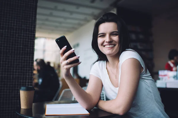 Positive Junge Studentin Weißen Shirt Surft Mit Handy Tisch Café — Stockfoto