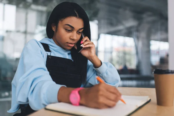 Menina Negra Escrevendo Algo Notebook Falando Smartphone Mesa Conceito Mulher — Fotografia de Stock